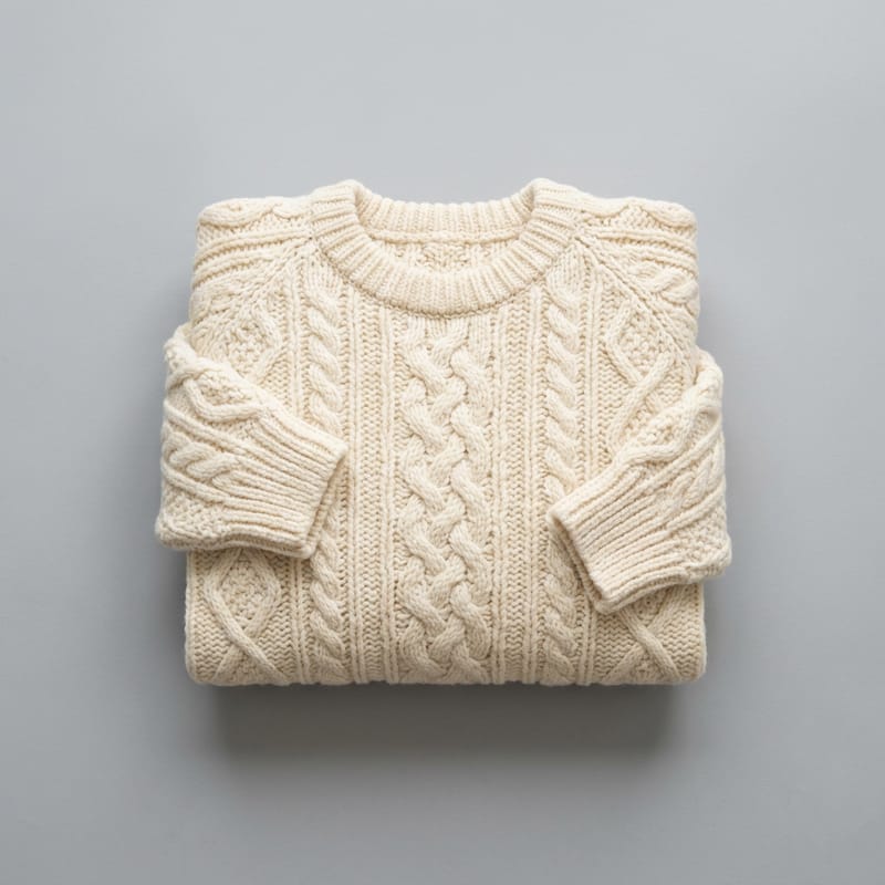 A cream cable-knit sweater folded